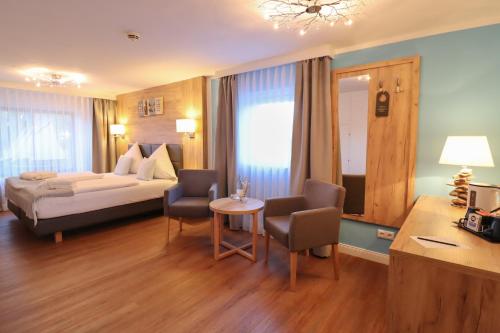a hotel room with a bed and a table and chairs at Hotel Das kleine Glück - Adults Only in Sankt Peter-Ording