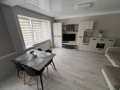 a kitchen and dining room with a table and chairs at ZE Apartments in Rēzekne
