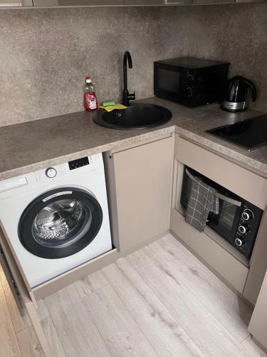 a kitchen with a washing machine and a sink at ZE Apartments in Rēzekne