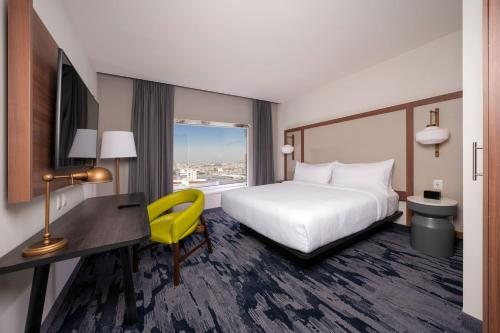 a hotel room with a bed and a desk and a yellow chair at Fairfield by Marriott Inn & Suites San Luis Potosi in San Luis Potosí