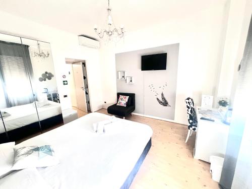 a white bedroom with a bed and a chandelier at Mia House Roma in Rome