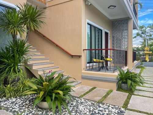 a house with a balcony with palm trees and plants at Angkearboss Villa in Kampot