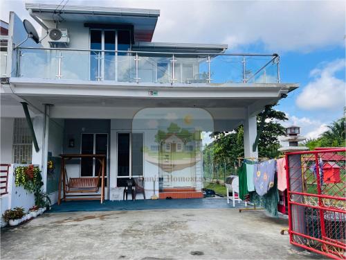 a white house with a balcony and a porch at Danial Homestay Semporna in Semporna