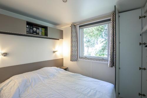 a bedroom with a bed and a window at Mobilhome tout confort in Saint-Jean-de-Monts