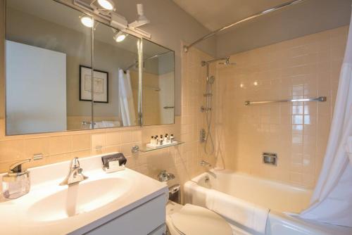 a bathroom with a sink and a toilet and a tub at CozySuites 800 Tower 1BR w sky pool, gym! 18 in Louisville