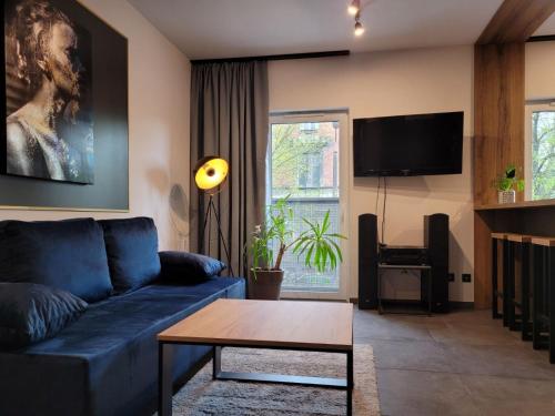 uma sala de estar com um sofá azul e uma mesa em Maxx Grey em Bielsko-Biala