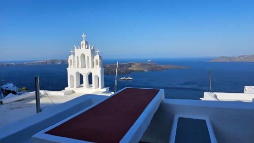 a large white building on the side of the ocean at Cactus cave house on the caldera in Firostefani