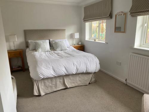 a bedroom with a bed with white sheets and pillows at Stunning 2 bed 2 bath house in Carleton in Pontefract