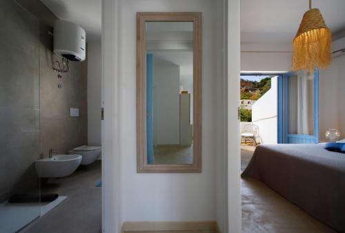 a bedroom with a mirror and a bed and a bathroom at Villetta Acacie in San Vito lo Capo