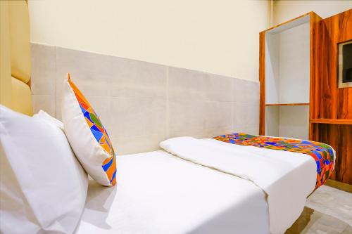 a bedroom with two beds and a mirror at FabExpress Emirates Suits in Mumbai