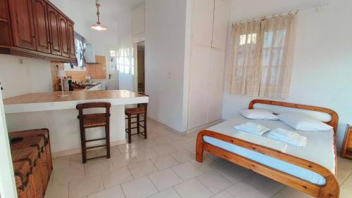 1 dormitorio con 1 cama y cocina con encimera en Enjoy sunset from a wonderful traditional studio-Melina, en Ioulida