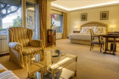 ラ・セウ・ドゥルジェイにあるHOTEL & SPA El Castell de Ciutatのベッド、テーブル、椅子が備わるホテルルームです。