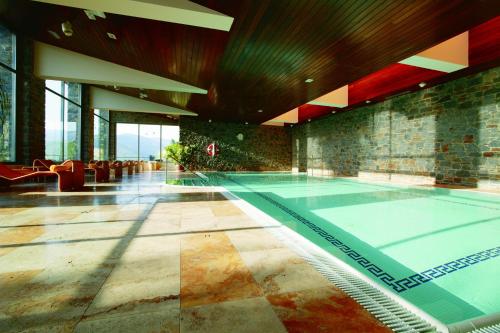 a large swimming pool in a building with at HOTEL & SPA El Castell de Ciutat in La Seu d'Urgell