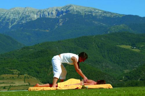a man laying on top of a person on a blanket at HOTEL & SPA El Castell de Ciutat in La Seu d'Urgell