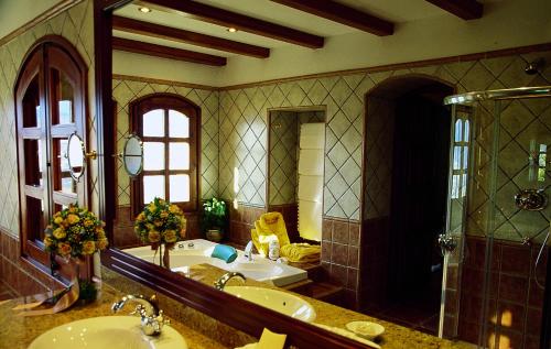 a bathroom with a sink and a tub and a mirror at HOTEL & SPA El Castell de Ciutat in La Seu d'Urgell