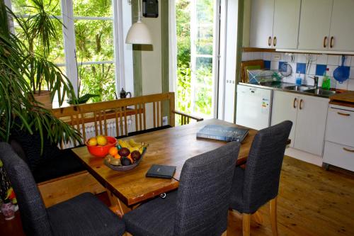 a kitchen and dining room with a wooden table and chairs at B&B Eco-Village 12 min from city in Stockholm