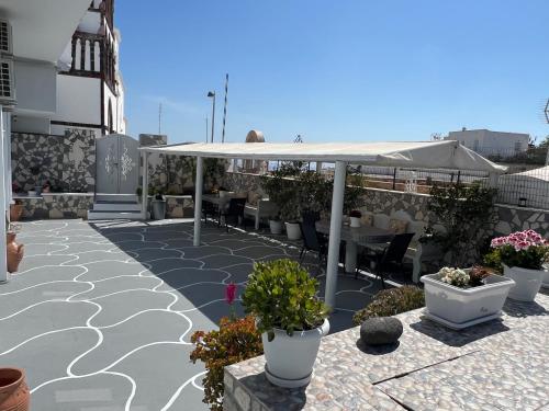 a patio with a white umbrella and some plants at Villa Pavlina in Karterados