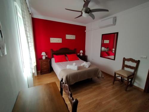 1 dormitorio con cama y pared roja en Casa / Apartamento Azahar, en Ronda