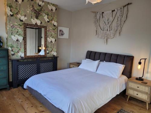 a bedroom with a large white bed and a mirror at George St Townhouse in Leamington Spa