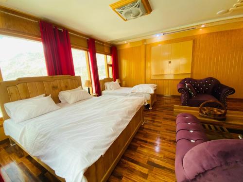 a bedroom with two beds and two chairs at North Palace Khaplu in Khaplu