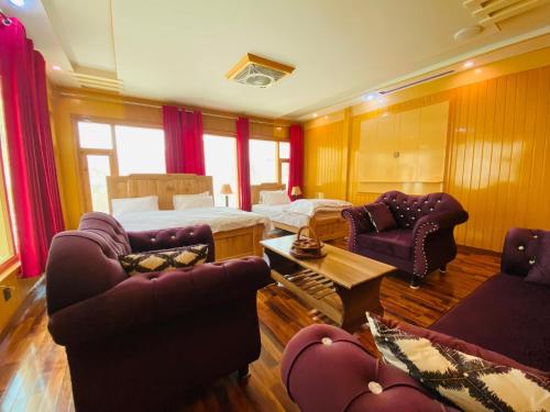 a hotel room with a bed and two couches at North Palace Khaplu in Khaplu