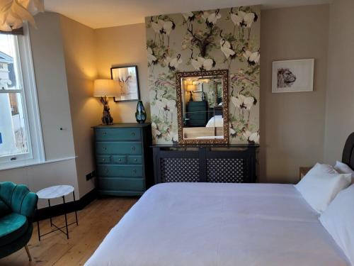 a bedroom with a large bed and a mirror at George St Townhouse in Leamington Spa