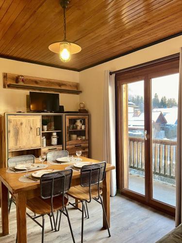 une salle à manger avec une table et des chaises et un balcon dans l'établissement Le Chaney - T2 dans chalet - Massif du Mont-Blanc, à Chamonix-Mont-Blanc