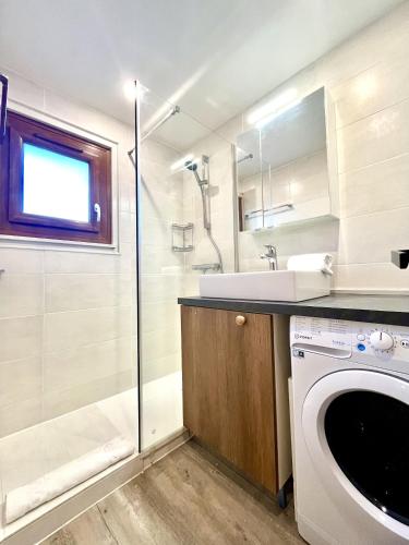 une salle de bain avec un lavabo et une machine à laver dans l'établissement Le Chaney - T2 dans chalet - Massif du Mont-Blanc, à Chamonix-Mont-Blanc