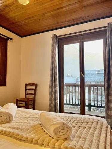 une chambre avec un lit et une grande fenêtre dans l'établissement Le Chaney - T2 dans chalet - Massif du Mont-Blanc, à Chamonix-Mont-Blanc