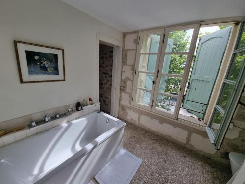 La salle de bains est pourvue d'une baignoire blanche et d'une fenêtre. dans l'établissement Magnifique villa à Montaud, à Montaud