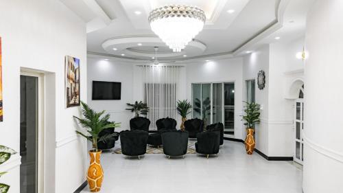 a living room with black chairs and a chandelier at ST Beach Villa in Kibweni