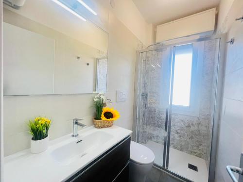 La salle de bains est pourvue d'un lavabo et d'une douche. dans l'établissement Appartamento Stella, à Bibione