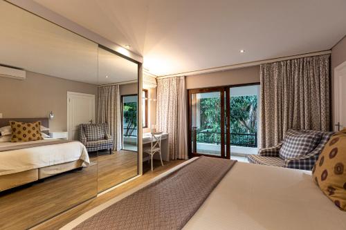 a bedroom with a bed and a large mirror at Hyde Park Guest House in Johannesburg