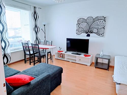 sala de estar con sofá y mesa con TV en Aurora City Apartment, en Rovaniemi