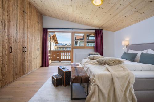 a bedroom with two beds and a large window at Kirchberg Chalet by Alpine Host Helpers in Kirchberg in Tirol