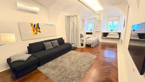 a living room with a black couch and a rug at Mart's Choice Apartment in Ljubljana
