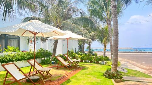 - un groupe de chaises longues et de parasols sur la plage dans l'établissement Coco Villa-đảo Phú Quý, à Cu Lao Thu