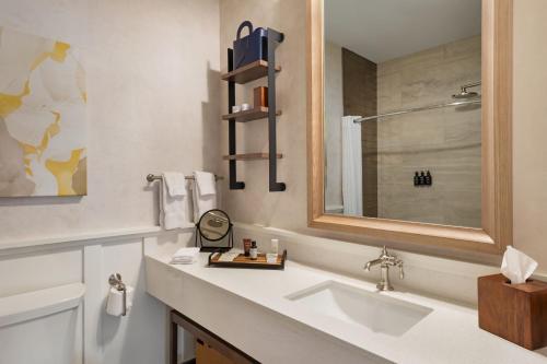 ein weißes Badezimmer mit einem Waschbecken und einem Spiegel in der Unterkunft The Lodge at Zion Country in Springdale