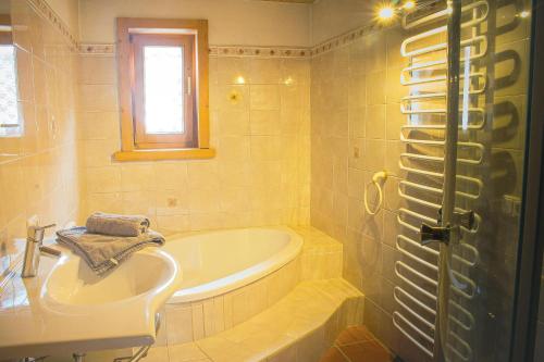 a bathroom with a tub and a sink at EMMA´s Chalet in Mayrhofen