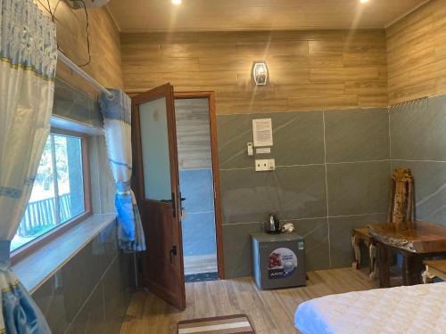 Zimmer mit einem Bett, einem Fenster und einer Tür in der Unterkunft Cát Tiên Hotel in Cat Tien