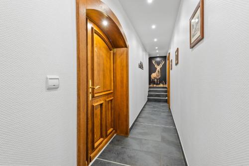 a hallway with a wooden door and a hallway with paintings at Smartstay au reve Savoyard - Studio N-6 in Morillon