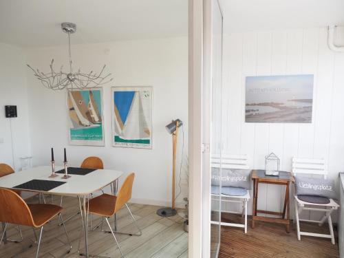 ein Esszimmer mit einem weißen Tisch und Stühlen in der Unterkunft Ferienwohnung Schleiverliebt 19-8 im Wikingturm Schleswig in Schleswig