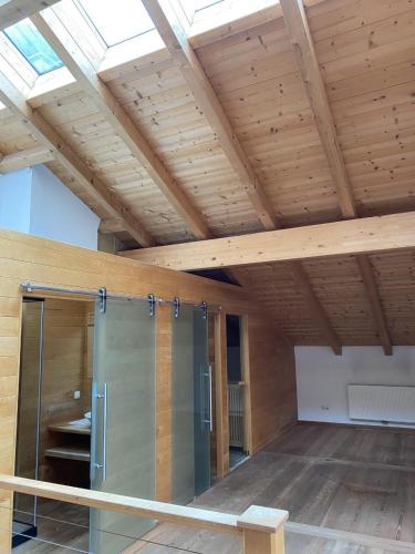 a room with a wooden ceiling and a glass door at EMMA´s Chalet in Mayrhofen