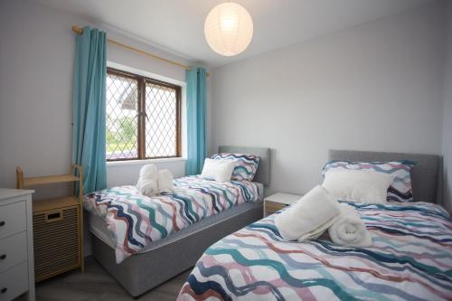 a bedroom with two beds and a window at Forest Park in Courtown