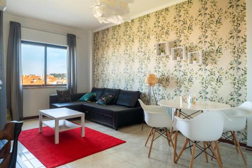 uma sala de estar com um sofá e uma mesa em Sea View & Sundown, 150m from the Beach and Surf Spots em Costa da Caparica