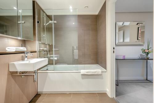 a bathroom with a tub and a sink and a shower at Merchant Square Paddington in London