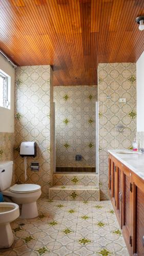 a bathroom with a shower and a toilet and a sink at Hostal La Buena Onda in Matagalpa