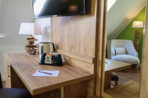 a room with a wooden desk with a television on it at Hotel Das kleine Glück - Adults Only in Sankt Peter-Ording