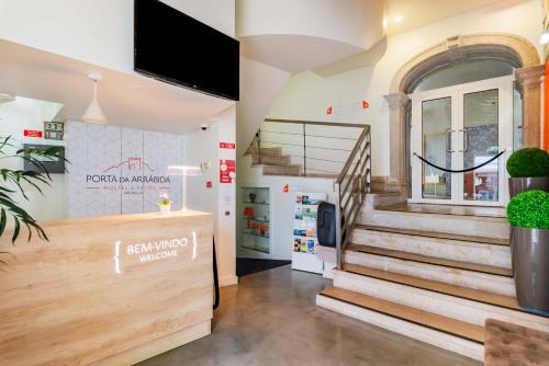 a store front with stairs and a tv on the wall at Porta da Arrábida Suites in Palmela