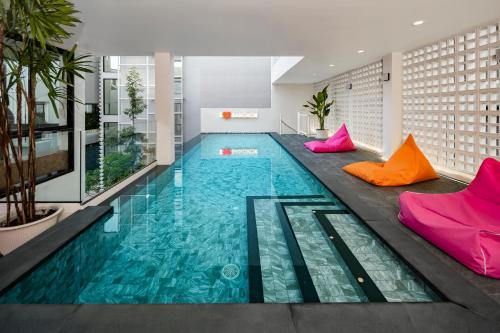 a swimming pool in a building with colorful pillows at 曼谷市中心素坤逸城中大宅豪华泳池河畔别墅 in Bangkok